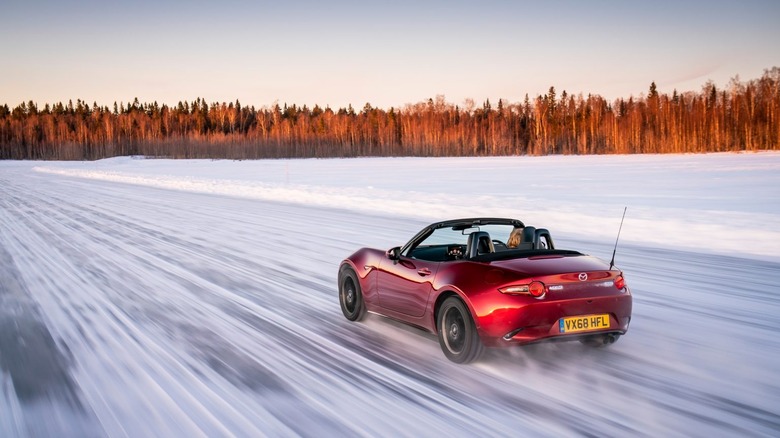A motion blur image of a Mazda Miata finished in Soul Red Crystal driving in the snow.