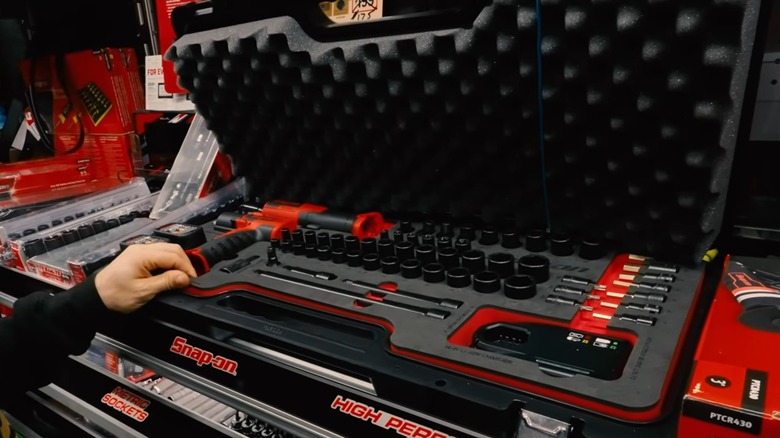 A person reaching into a box of Snap-On tools.