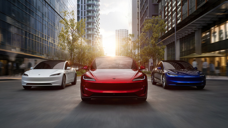 Three Tesla Model 3s driving side-by-side in an urban environment