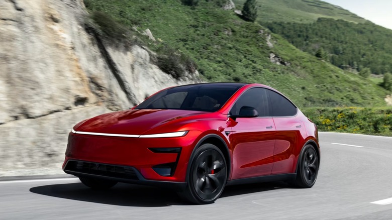 Red Tesla Model Y driving down the road