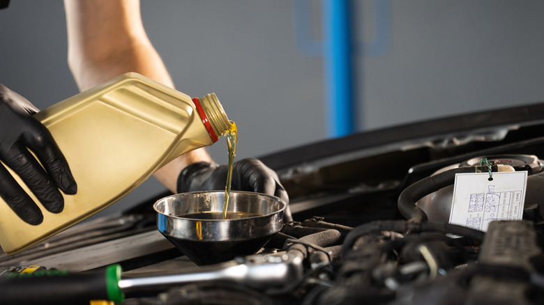 Close up of oil being poured into an engine