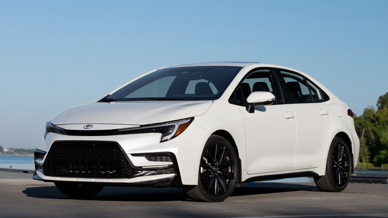 Front 3/4 view of Toyota Corolla in forested seaside setting