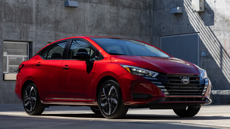 Front 3/4 view of 2025 Nissan Versa in industrial setting