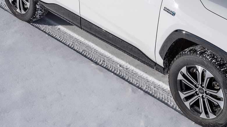 Closeup overhead view of car making tracks in snow