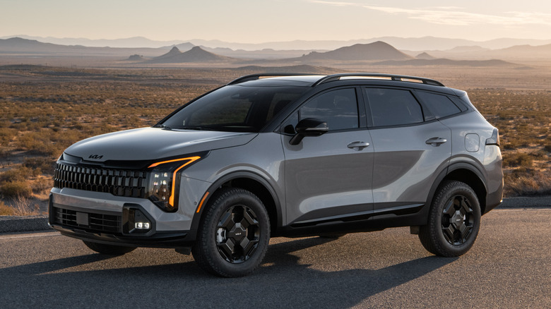 Gray Kia Sportage parked on a desert road at sunset