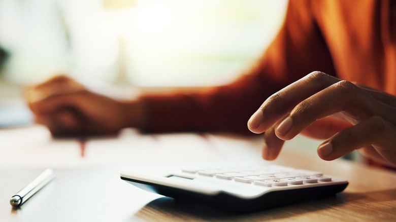 Person with documents and a calculator