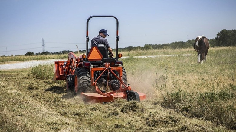 Kubota B01 Series cutting thick grass on a farm