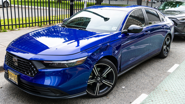 Blue Honda Accord parked by a fence