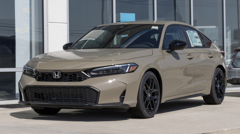 Beige 2025 Honda Civic parked by a dealership