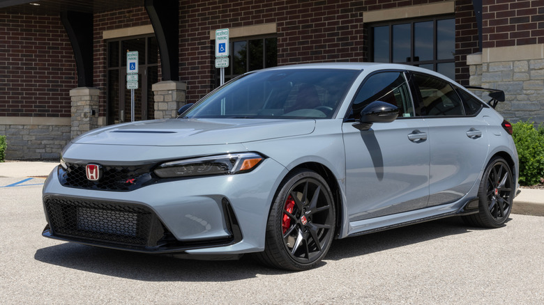 A nardo blue 2024 Honda Civic Type R parked outside a red brick building.