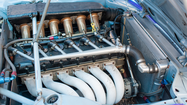 A six-cylinder engine in a classic car with individual throttle bodies