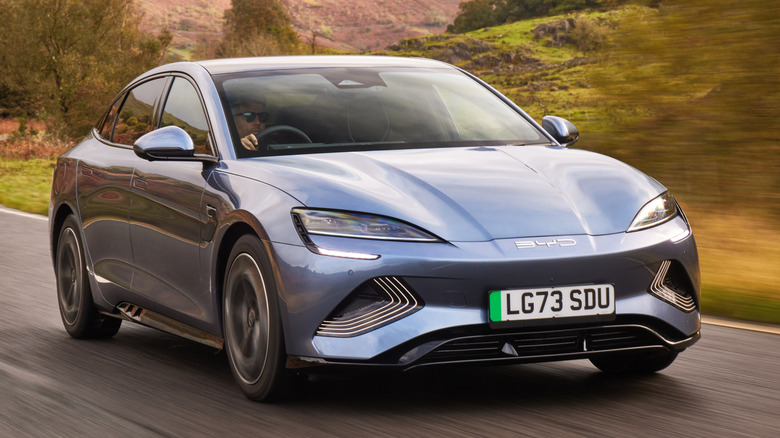 A grey BYD Seal with UK licence plate driving through countryside.