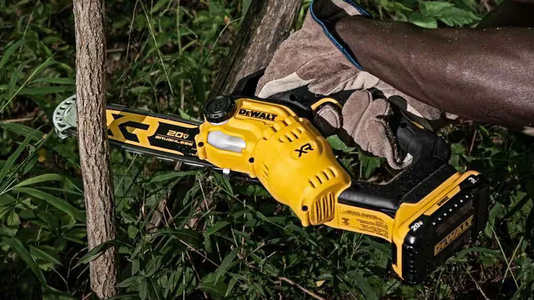 DeWalt pruning chainsaw cutting through branch