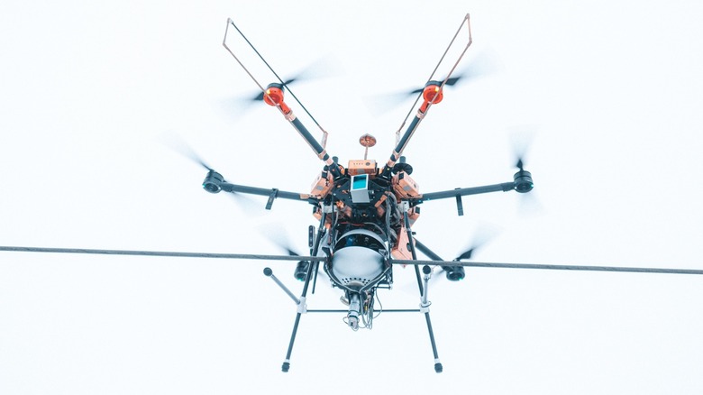 A drone installing a Heimdall Power Neuron device on a power line