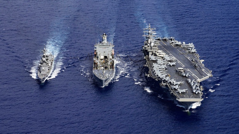 Japanese destroyer, USNS John Ericsson, and USS Ronald Reagan at sea in a row