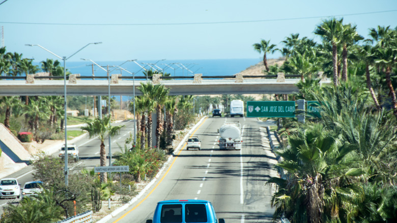 Highway 1 between Cabo San Lucas and San Jose Del Cabo. The vehicles are primarily those of residents with a few tourist rentals.