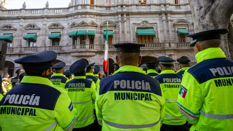 Back view of the municipal police of Puebla with the "Policia Municipal" logo emblem on uniform, maintains public order on the streets.
