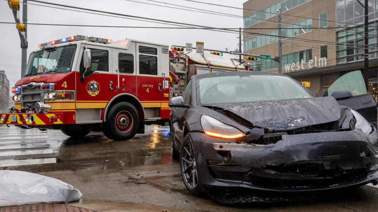 Tesla vehicle seen after crash with firetruck in background
