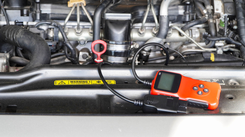 A diagnostic tool reads a car engine