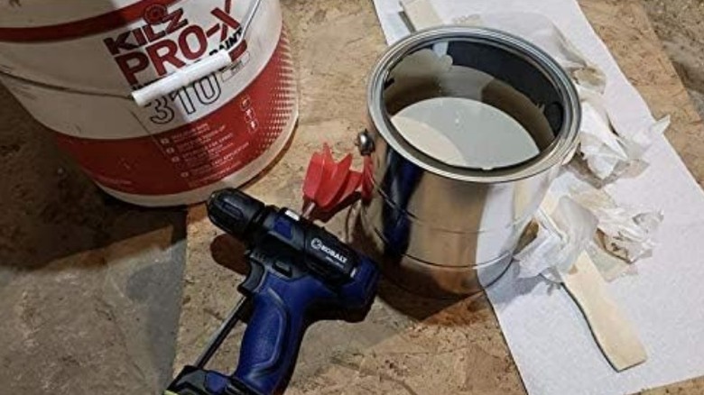Edward Tools Paint Mixer Drill Attachment head under a drill and next to a can of paint