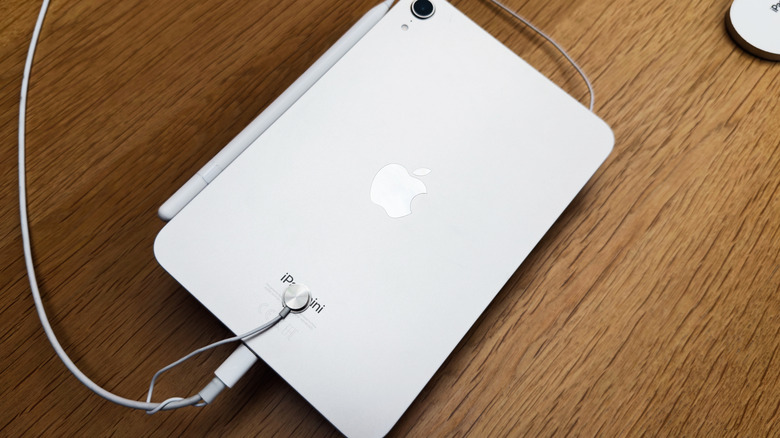 An iPad Mini plugged in on a table.