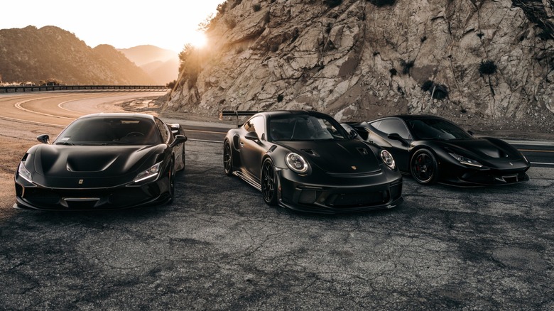 three black sports cars on the side of the road