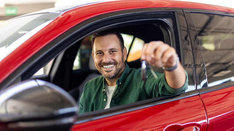 Smiling man holding a car key