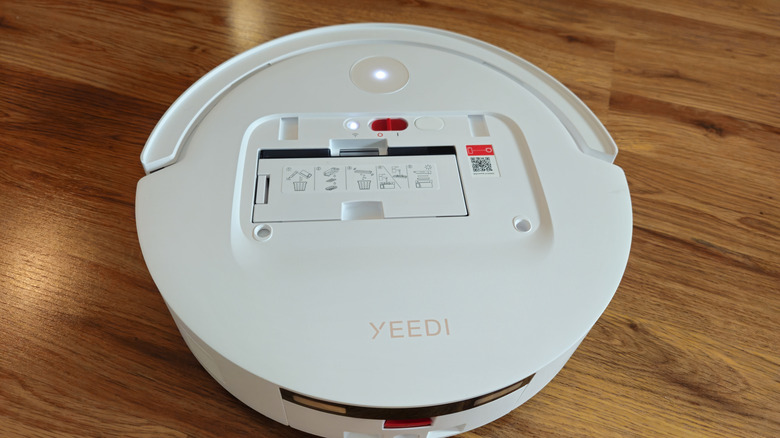 The top buttons of the YEEDI M14 Plus robot vacuum on a hardwood floor