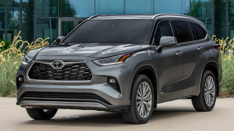 Front 3/4 view of Toyota Highlander Hybrid in front of modern building