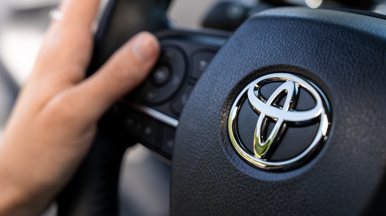 Close-up of a hand on a Toyota steering wheel