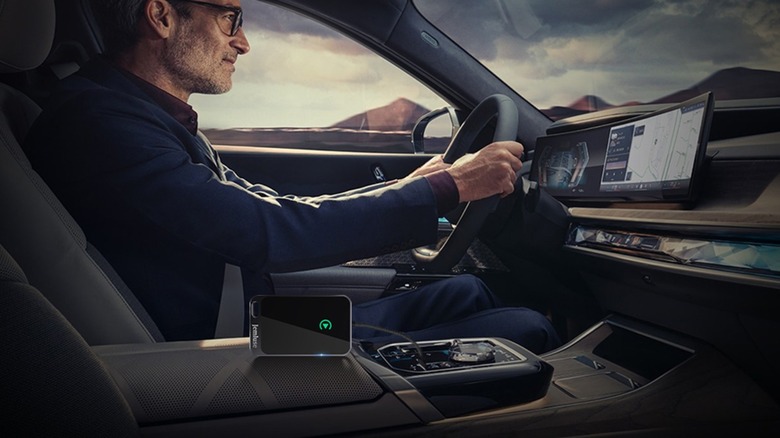 man in car with CarPlay adapter