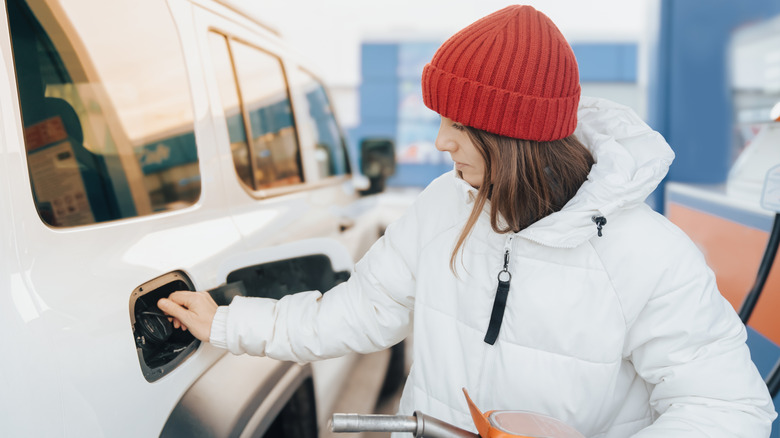 Woman pumping gas in winter