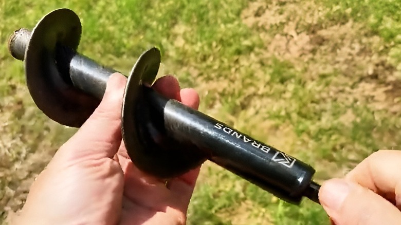 Hands holding a K-Brands auger drill bit