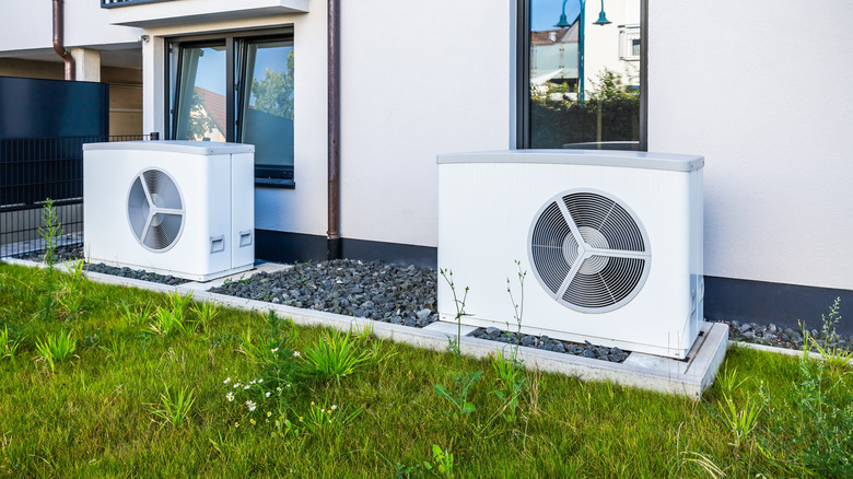 A pair of air source heat pumps outside a modern house