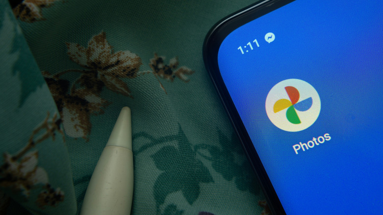 Google Photos logo on a smartphone with a blue screen.