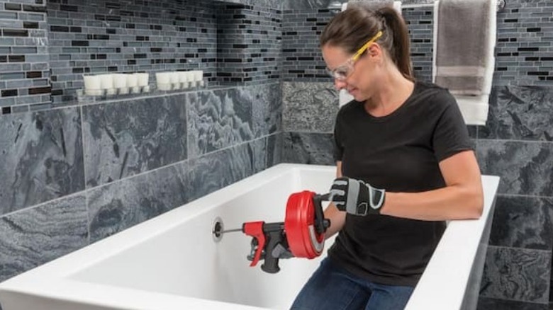 Womain using ridgid drain snake in tup