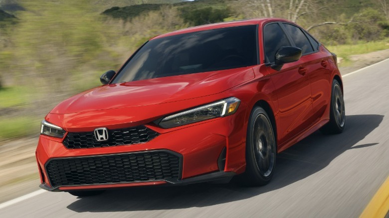 Red 2025 Honda Civic driving on a rural road