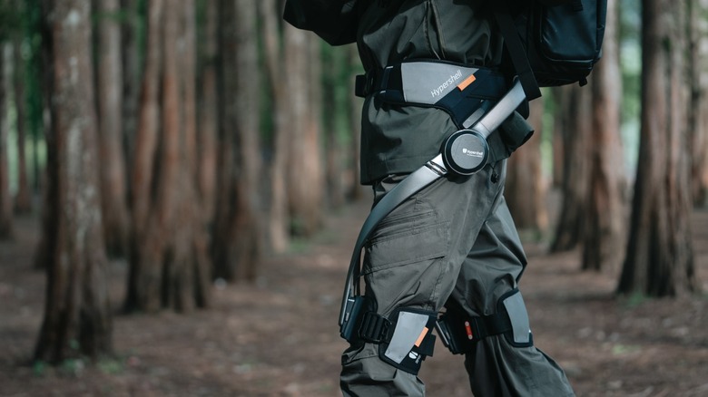 Person wearing Hypershell exoskeleton in forested terrain