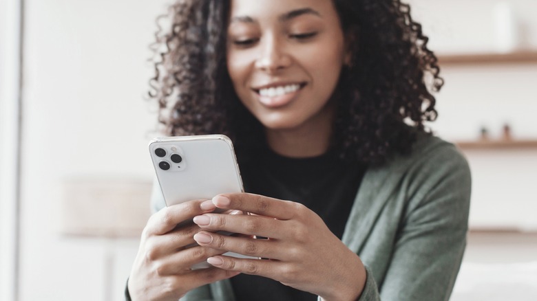 Smiling while looking at smartphone