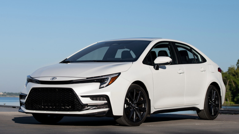 Front 3/4 view of 2025 Toyota Corolla parked by the water