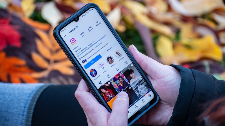 User scrolling Instagram on a smartphone outdoors