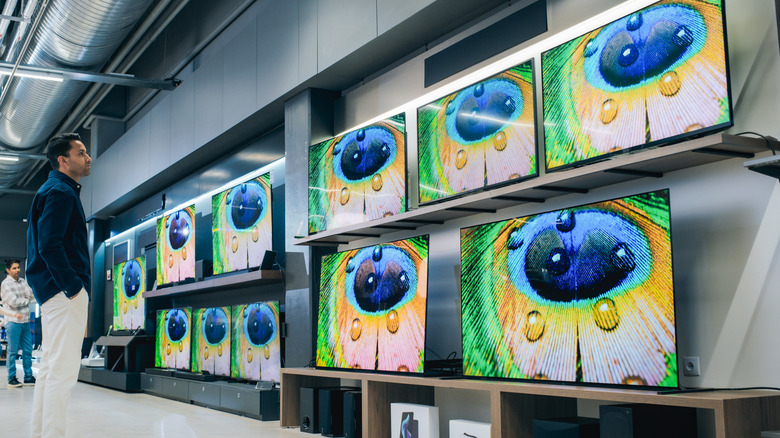 Man looking at TVs on display