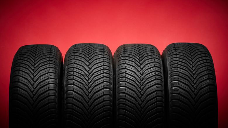 Car tires, winter wheels isolated on red background
