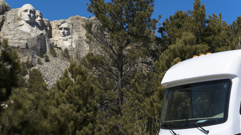 An RV parked with Mt Rushmore in the background