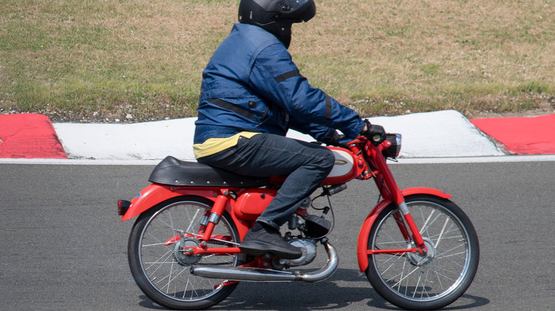 Person riding an Aermacchi Harley-Davidson M50 at a rally