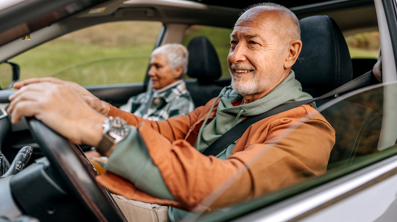 A senior mail driver with a senior female front passenger.