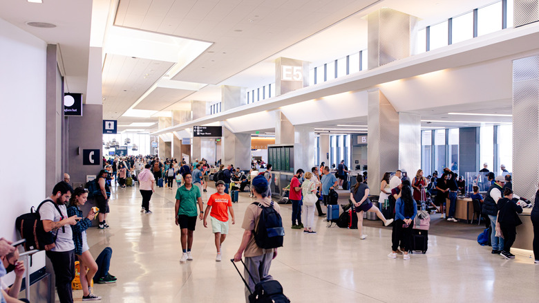 Travelers inside a busy airport