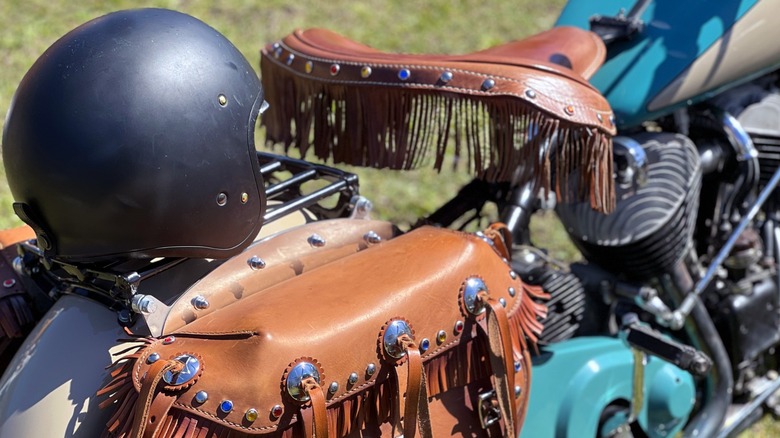 A motorcycle helmet sitting on the rear rack of a Harley-Davidson.