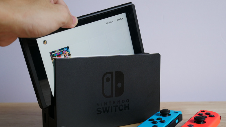 person removing Nintendo Switch from dock