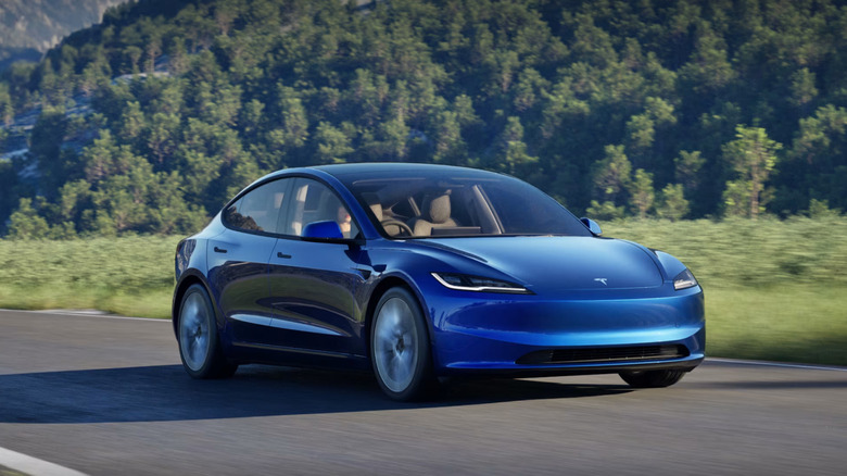 Front shot of a blue Tesla Model 3 driving